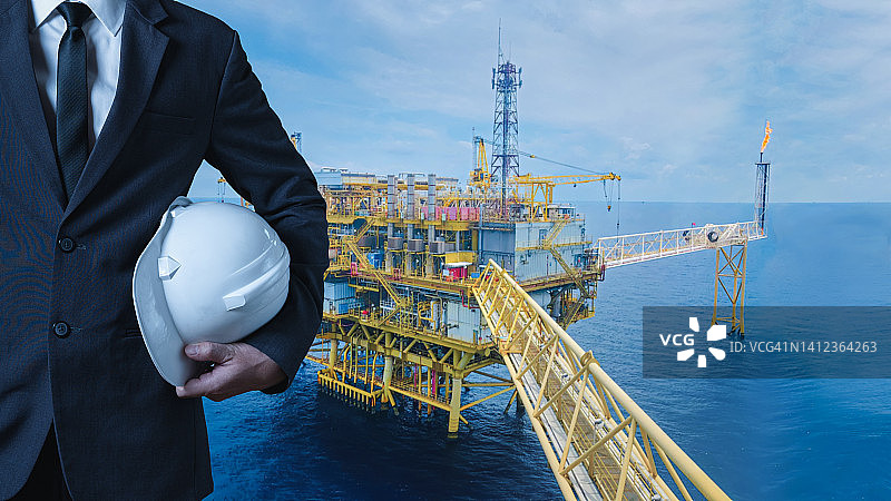 商人或工程师和海上钻井平台的石油和能源概念图片素材