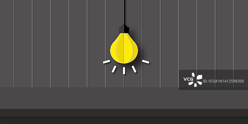深色木质背景上的黄色灯泡。想法、灵感、企业财务或目标的成功。图片素材
