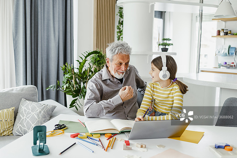 爷爷在帮他的孙女做作业图片素材