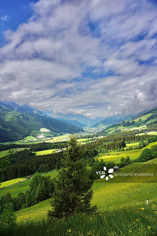 巴伐利亚山谷的一个村庄，俯视。夏天的巴伐利亚村庄在群山之间。蓝天白云下的德国村庄。图片素材