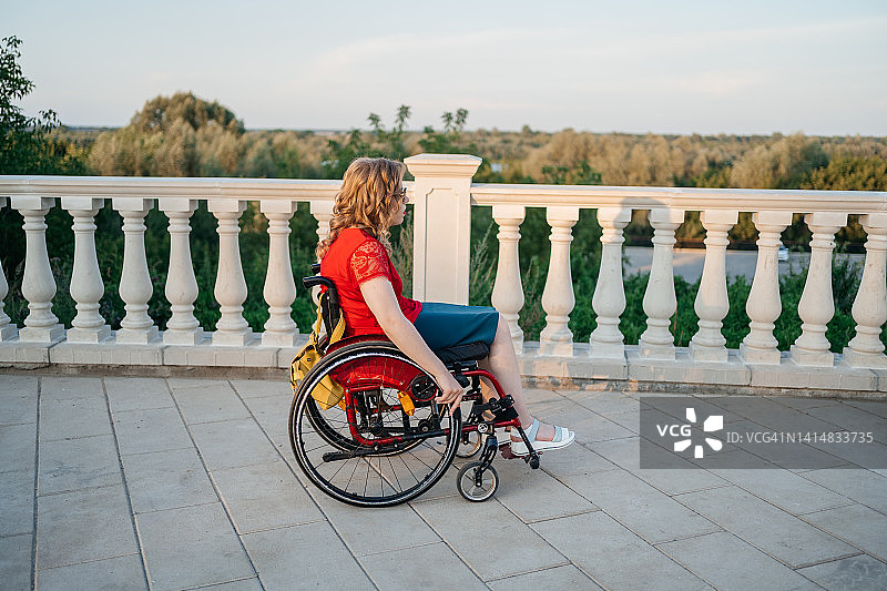 一个坐轮椅的脑瘫女孩在公园散步图片素材