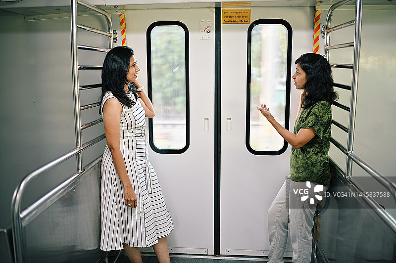 两个女人站在火车门口互相议论着图片素材