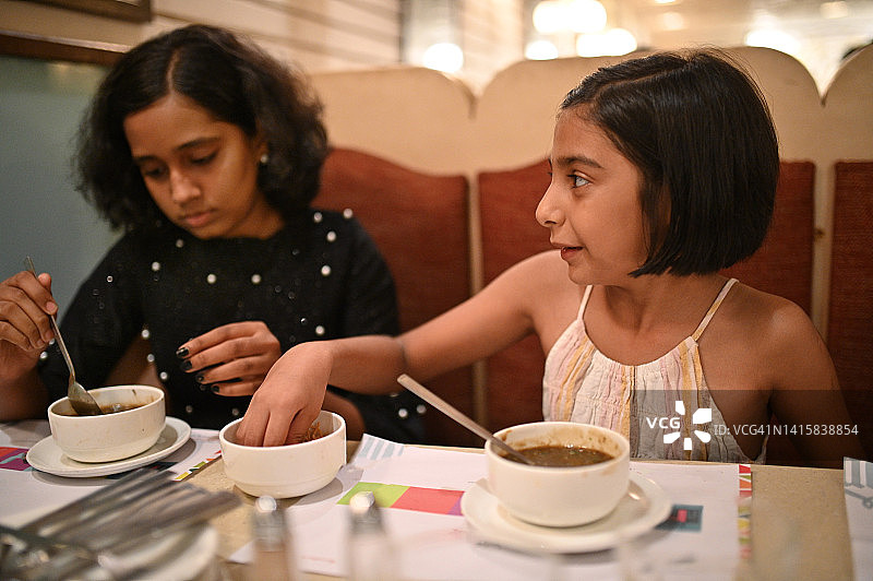 两个可爱的女孩在餐厅喝汤图片素材