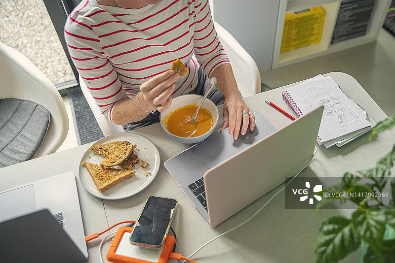 成熟女性在家工作的时候吃午饭图片素材