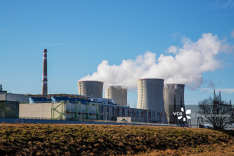 欧洲捷克共和国的杜科瓦尼核电站。烟冷却塔。天空中有云。背景是高地的自然风光。图片素材