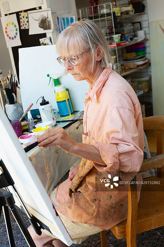 一位艺术家的肖像:一位资深女性在她的工作室图片素材