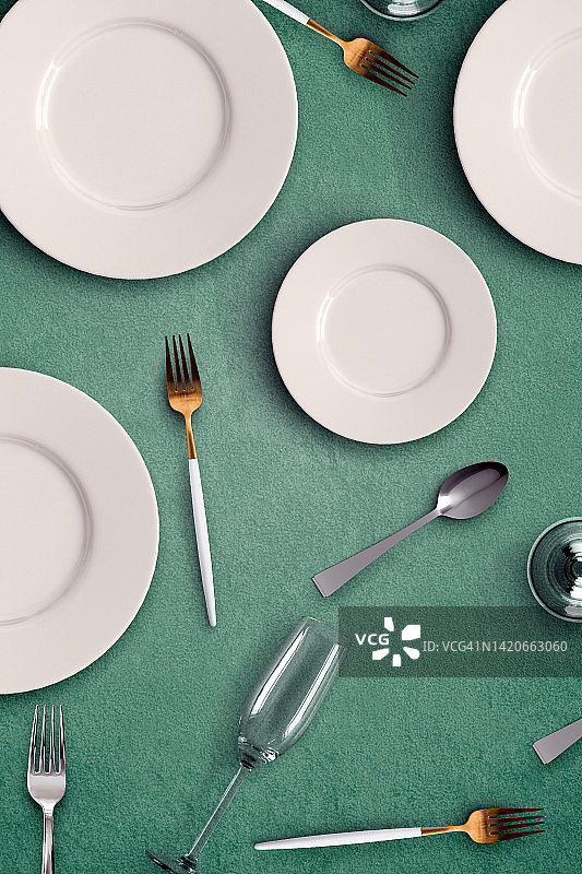 空盘子桌子设置我与叉子，勺子，杯子在绿色的背景图片素材