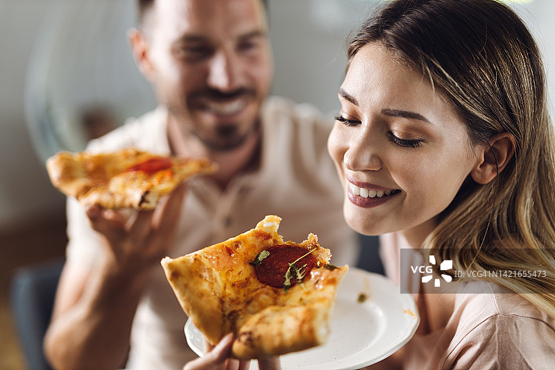 一对年轻夫妇在家里吃披萨图片素材