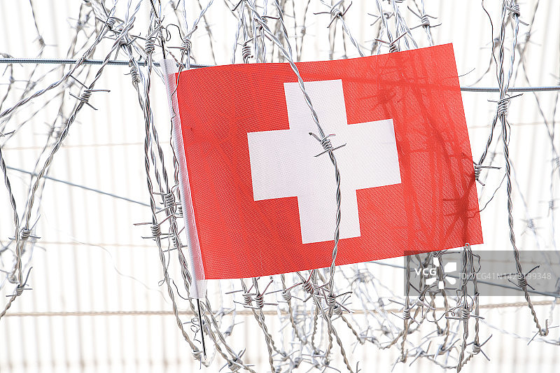 挂在铁丝网上的瑞士国旗。图片素材