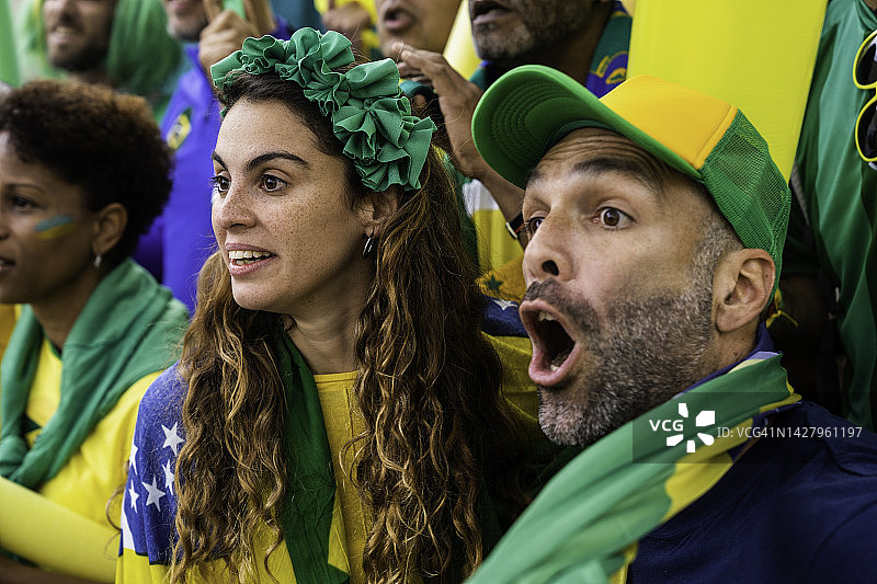 一对巴西夫妇一边观看比赛一边为国家足球队加油图片素材