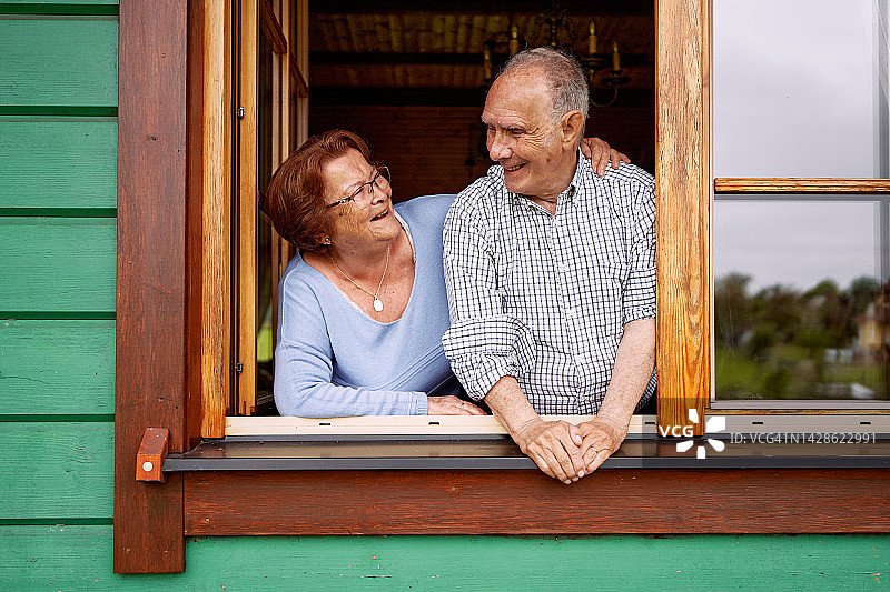 一对老夫妇靠在窗户上笑图片素材
