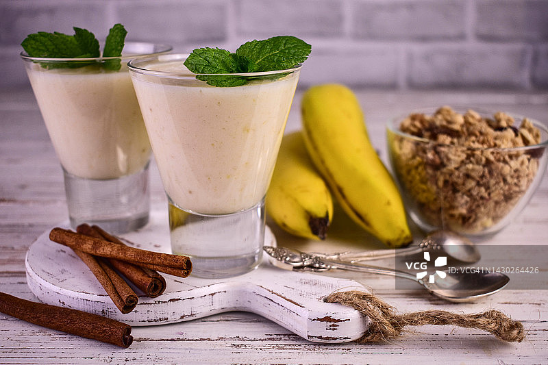香蕉肉桂酸奶和格兰诺拉麦片。健康的甜点的概念。图片素材