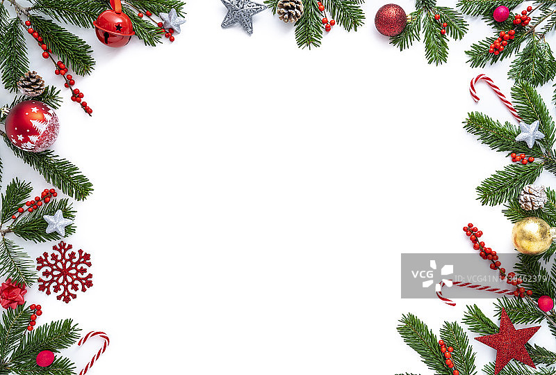 圣诞边界框架与冷杉树和冬青浆果，小玩意，雪花，糖果拐杖对白色图片素材
