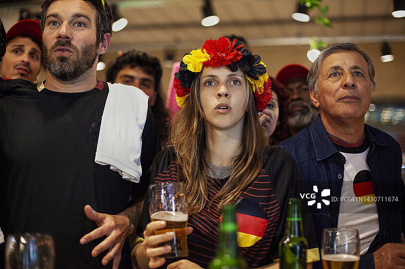 一群德国朋友在体育酒吧一起观看国家队足球比赛的正面视图图片素材