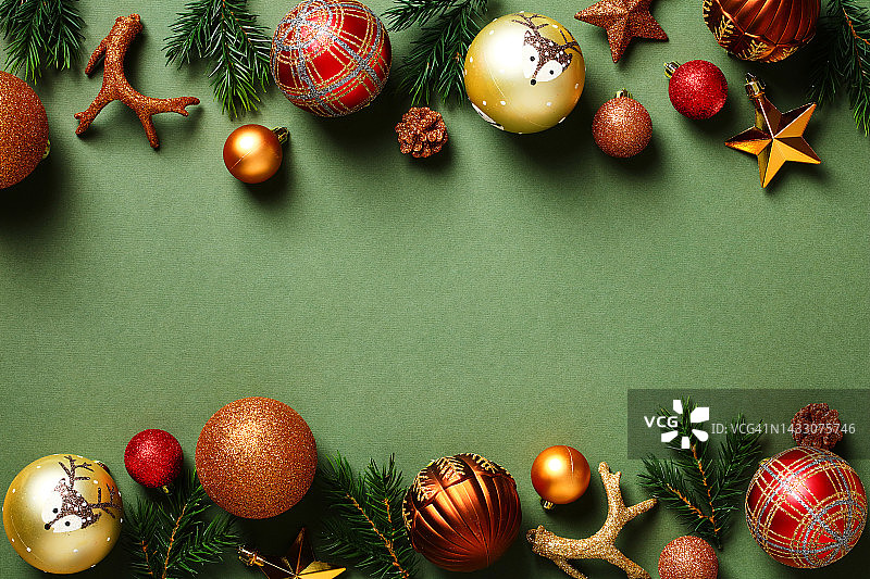 老式圣诞卡模板。复古的圣诞装饰品，小玩意，星星，鹿角，深绿色背景的圣诞树枝。图片素材