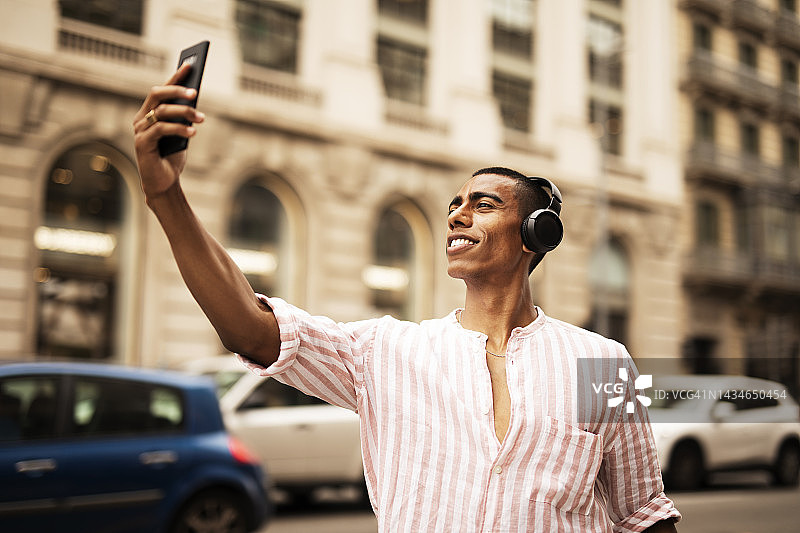 年轻的非洲人在户外听音乐图片素材
