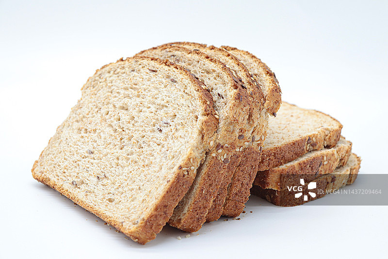 切片的全麦面包，白色的背景。健康食品的概念，均衡的早餐，纤维食品。图片素材