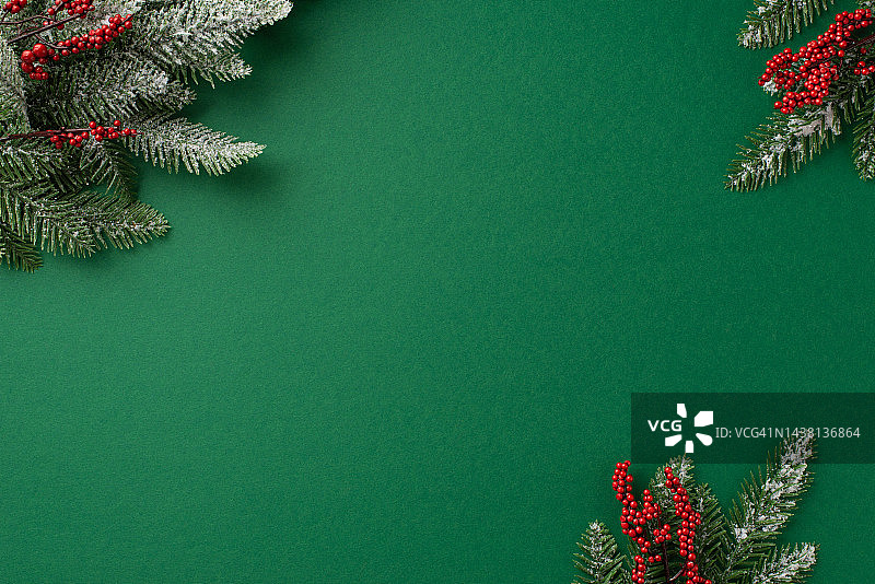 圣诞夜的概念。俯视图照片槲寄生浆果和松树树枝在白霜上孤立的绿色背景与空白图片素材