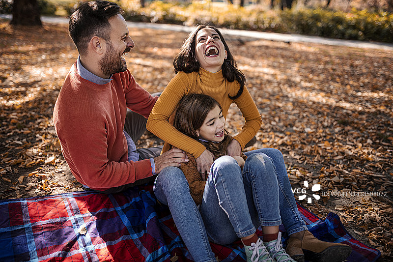 一个幸福的家庭在公园里度过一个美丽的秋日图片素材