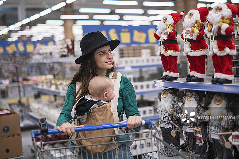 一名妇女和她的孩子在购买圣诞装饰。图片素材