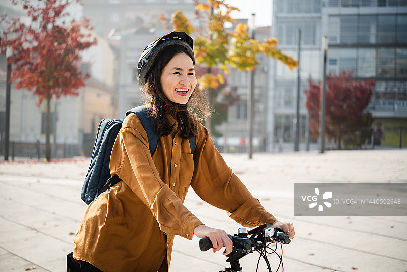 一个美丽的日本女人骑着自行车去上班的画像图片素材