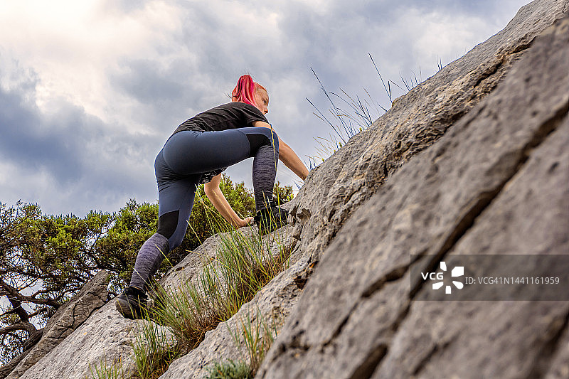 登山者-十几岁的女孩爬上岩石图片素材
