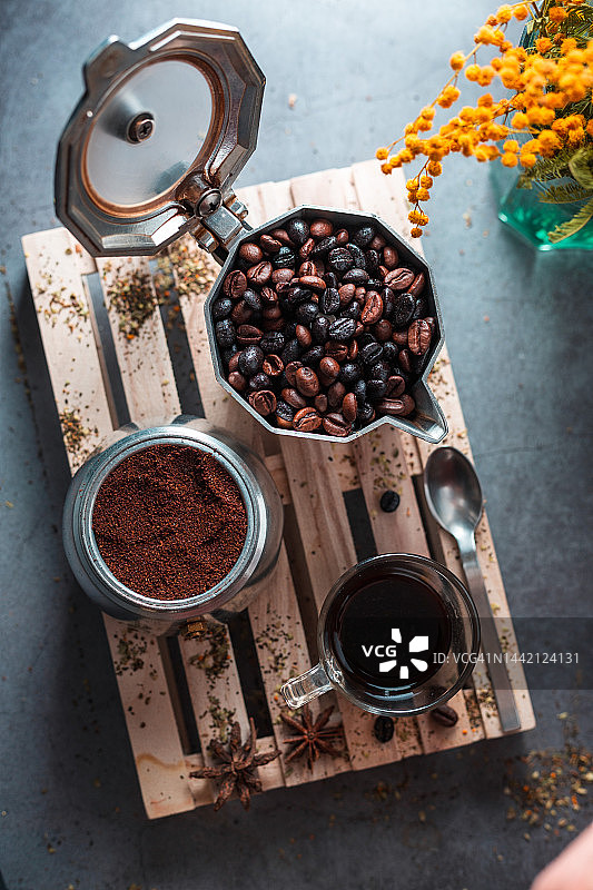 俯视图的咖啡豆和磨碎的咖啡在壶旁边的杯子。图片素材