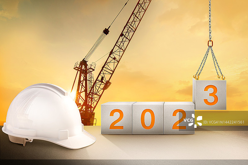 工程工作台和建筑起重机剪影和金色天空，准备迎接2023年新年晚会和改变新的业务。图片素材