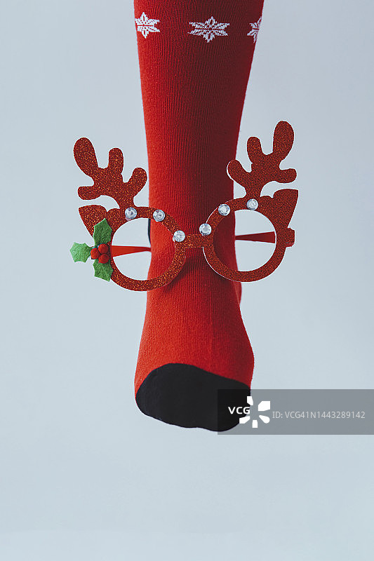 女孩的腿，红色的圣诞袜和驯鹿鹿角眼镜图片素材