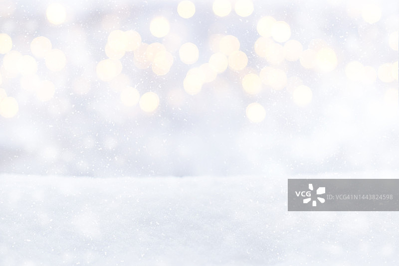 雪景背景上模糊的圣诞彩灯。冬天的背景，白色的雪，闪光的散焦灯，散焦，雪花和降雪图片素材