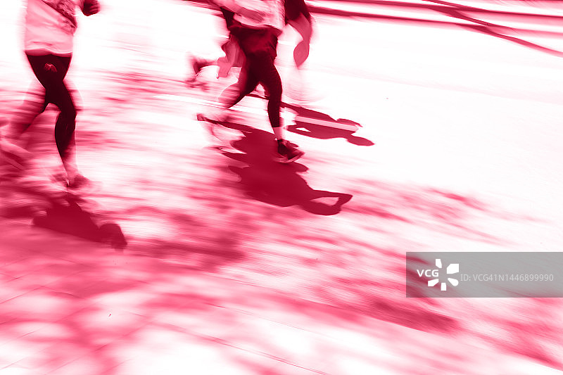 品红色调模糊图像组未知的人在路上跑图片素材