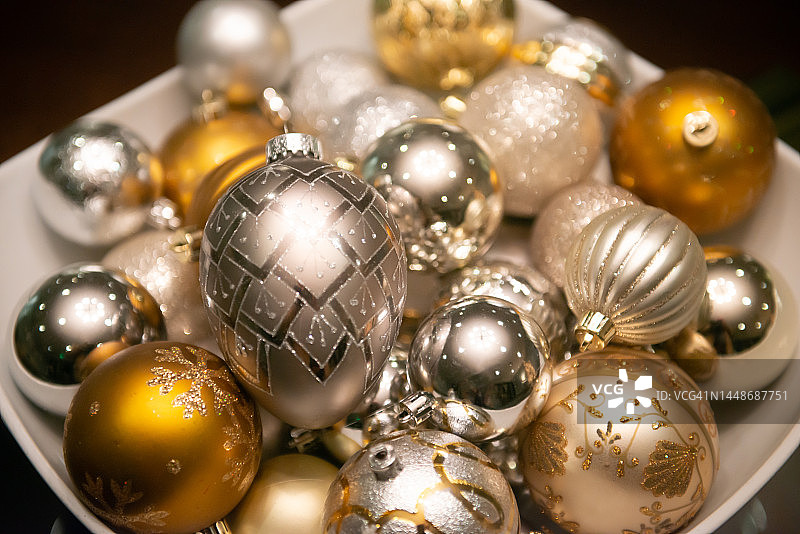 在一个碗里的节日银和金圣诞小玩意的特写图片素材