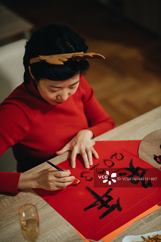 年轻的亚洲妇女为中国新年做祝福卡图片素材