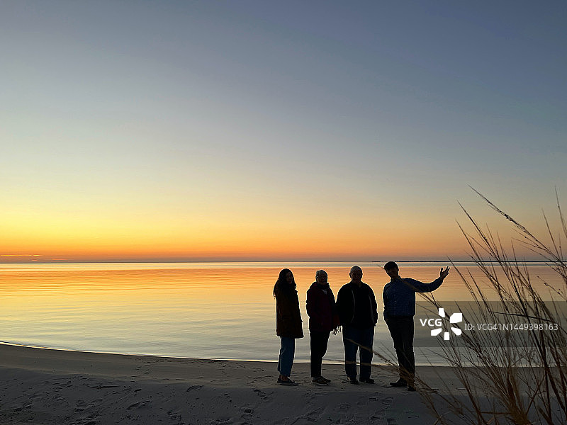 几代人的家庭聚集在丹吉尔海湾欣赏感恩节的日落。东部海岸。切萨皮克湾。图片素材