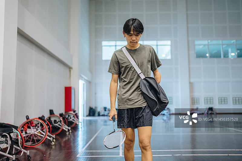 自信的肖像一个残疾的亚洲人拿着羽毛球拍。图片素材