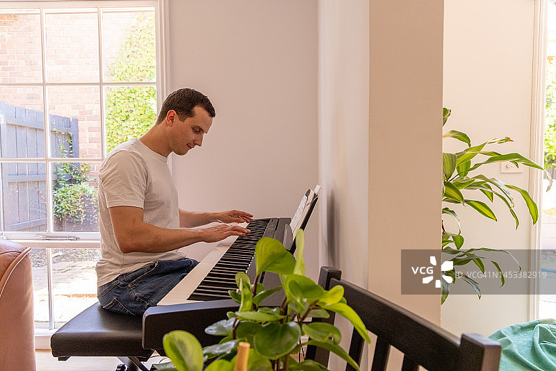 快乐的人在家里弹钢琴图片素材