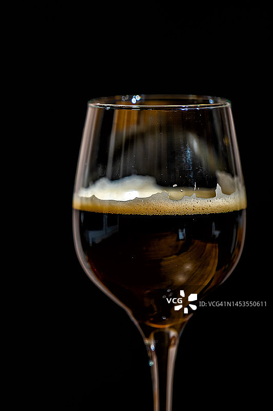 黑啤装在黑色背景的玻璃杯里。图片素材