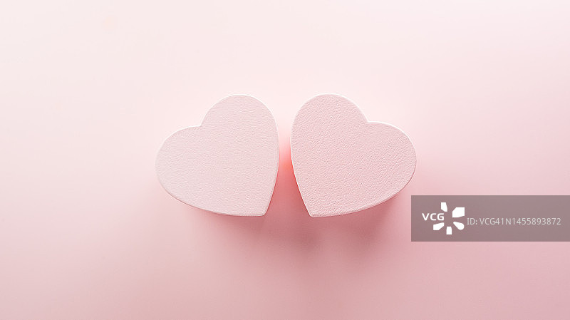 情人节快乐和爱情装饰背景概念由两颗心在粉彩粉红色的背景。图片素材