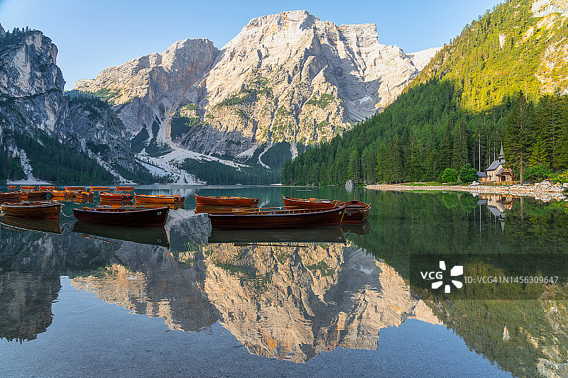 拉戈迪布雷斯(Pragser Wildsee)与木船的惊人日出景观，这是意大利多洛米蒂山脉南蒂罗尔最美丽的湖泊之一。热门旅游景点。图片素材
