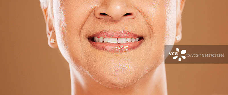 牙齿，牙科和高级妇女在工作室孤立的棕色背景。口腔护理，健康或近距离微笑的老年女性模型与自然看起来贴面为美丽和健康的牙齿卫生图片素材