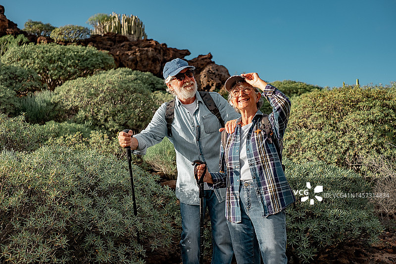 微笑的老夫妇享受户外远足山区环境。美丽活泼的老年人退休后生活方式健康图片素材