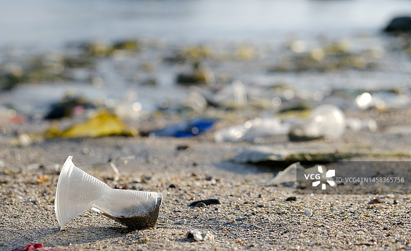海滩上有很多垃圾，塑料杯和塑料袋。海洋垃圾是世界上主要的环境问题之一。
保护环境和海洋自然图片素材