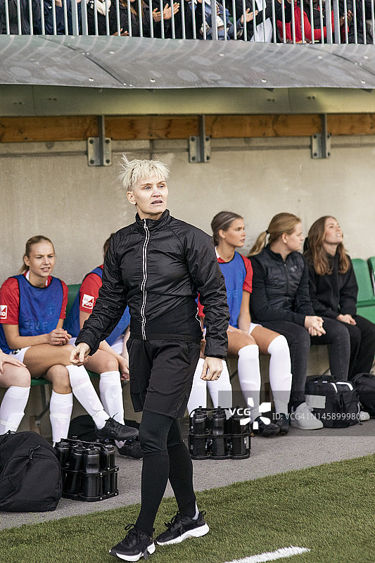 成熟的女教练在体育场足球比赛中行走图片素材