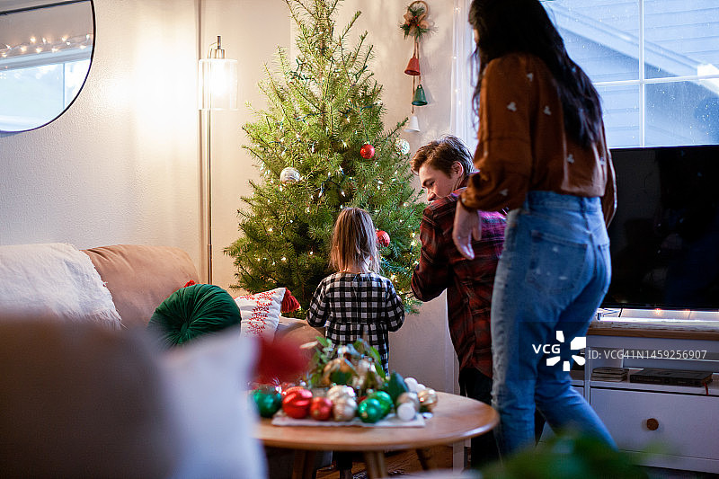 家庭和两个孩子装饰圣诞树图片素材