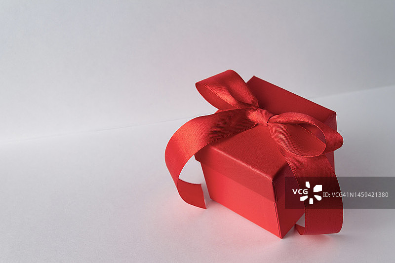 红色礼盒用丝带系在白色背景上，复制空间图片素材