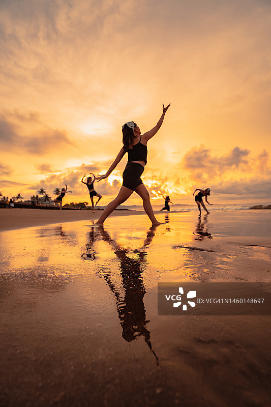 节日开始前，一群亚洲女性在海滩上一起跳芭蕾舞图片素材