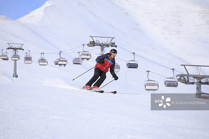 男子滑雪者滑雪，享受在滑雪场。高速滑雪雕刻。高山雪景。欧洲阿尔卑斯山脉图片素材