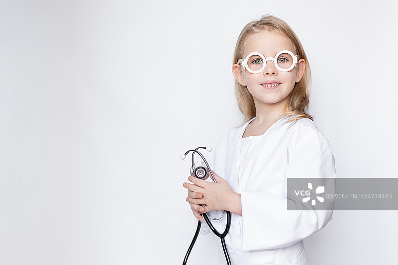 乌克兰基辅，小女孩穿着医生装，手拿听诊器，戴着玩具眼镜图片素材