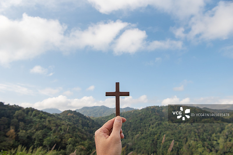 女孩祈祷与十字架在自然日出的背景图片素材