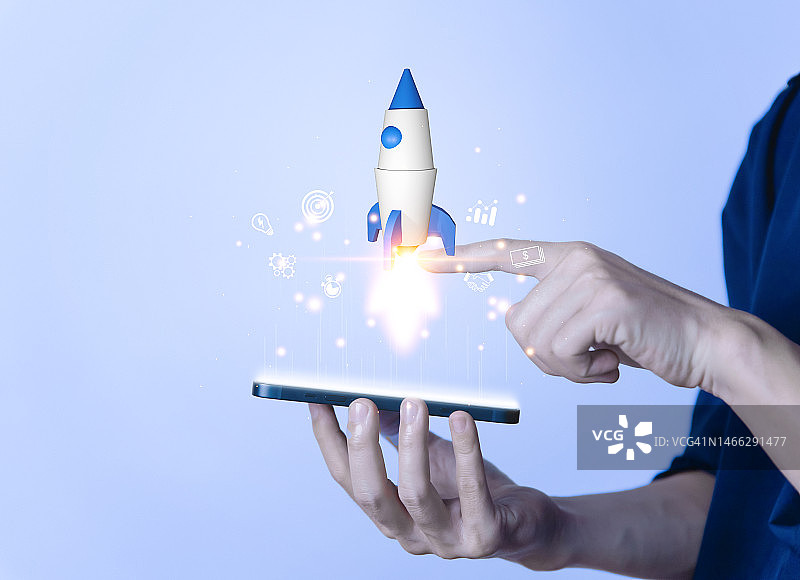 商人用智能手机触摸火箭图标。创业企业家的概念。网络营销，技术和图片素材